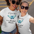 Two smiling women in sunglasses and matching tees with blue butterflies and "A good friend is a cherished treasure." taking a selfie.
