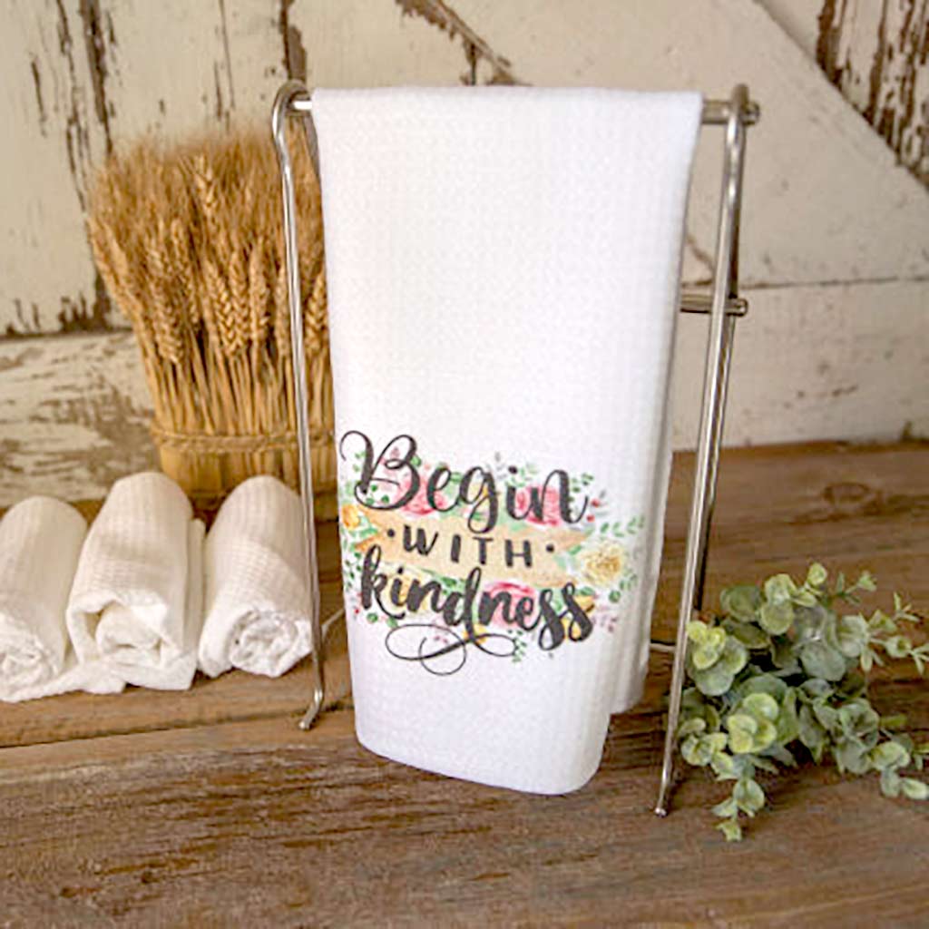 Begin With Kindness dishtowel with colorful floral detail.