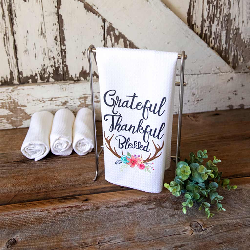 Lovely Fall Grateful Thankful Blessed Kitchen Towel on a table with a decorative succulent and a barn door in the background
