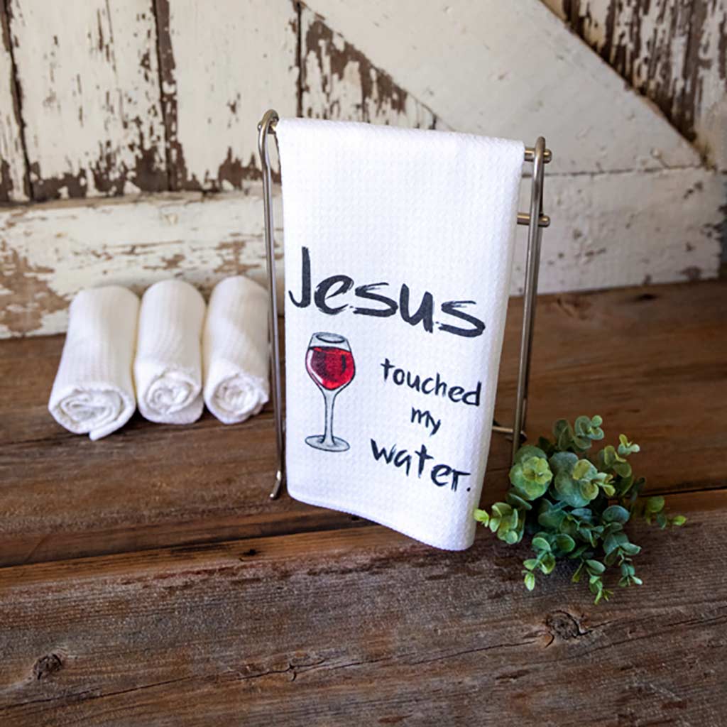 Jesus touched my water. dishtowel with a glass of red wine on it.