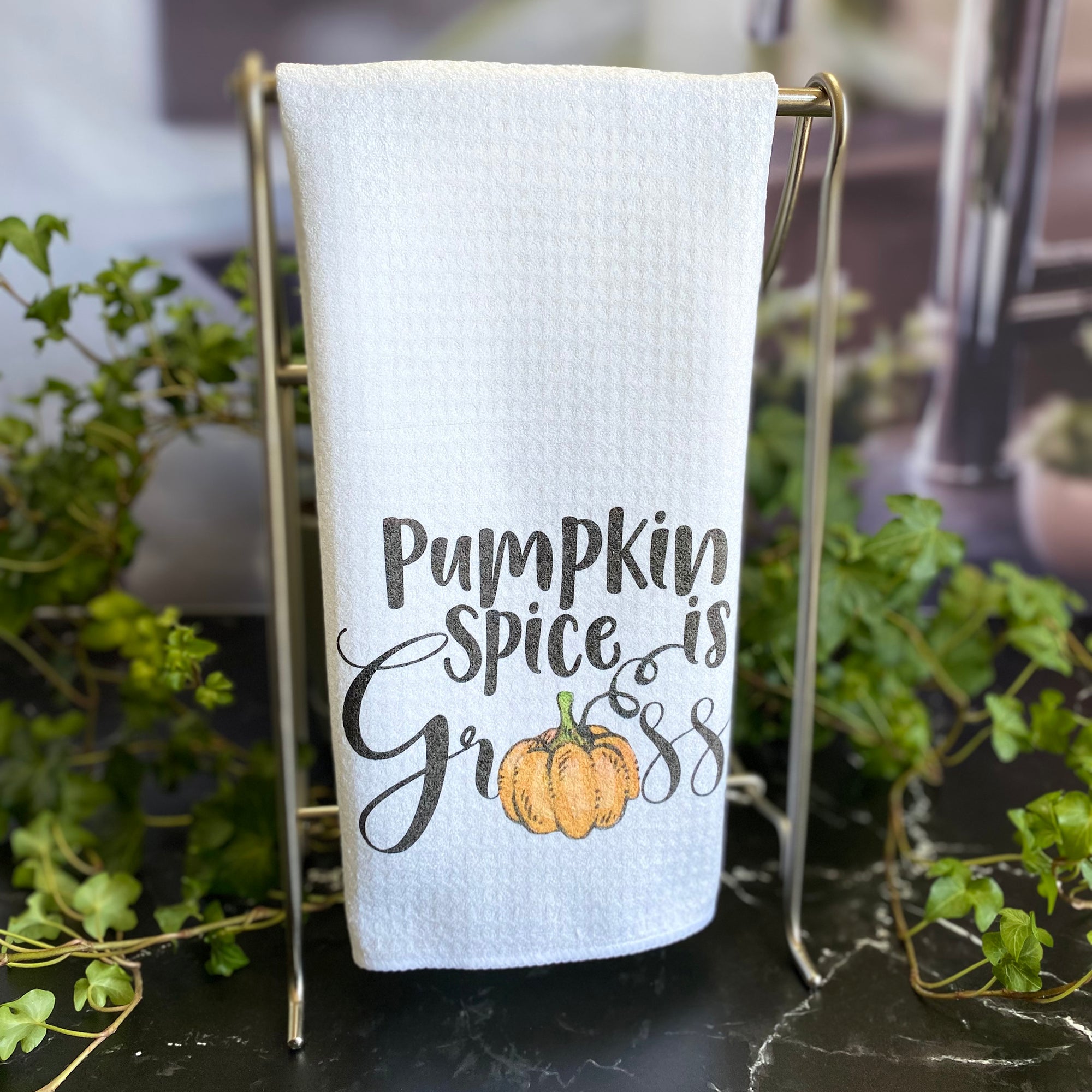 White waffle weave dishtowel with the words, "Pumpkin spice is gross" with a pumpkin instead of the letter 'o'.