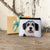 Black and White Dog printed on a small coin purse with a brown craftpaper giftbox behind it, tied with a light teal satin ribbon, resting against an old white barndoor