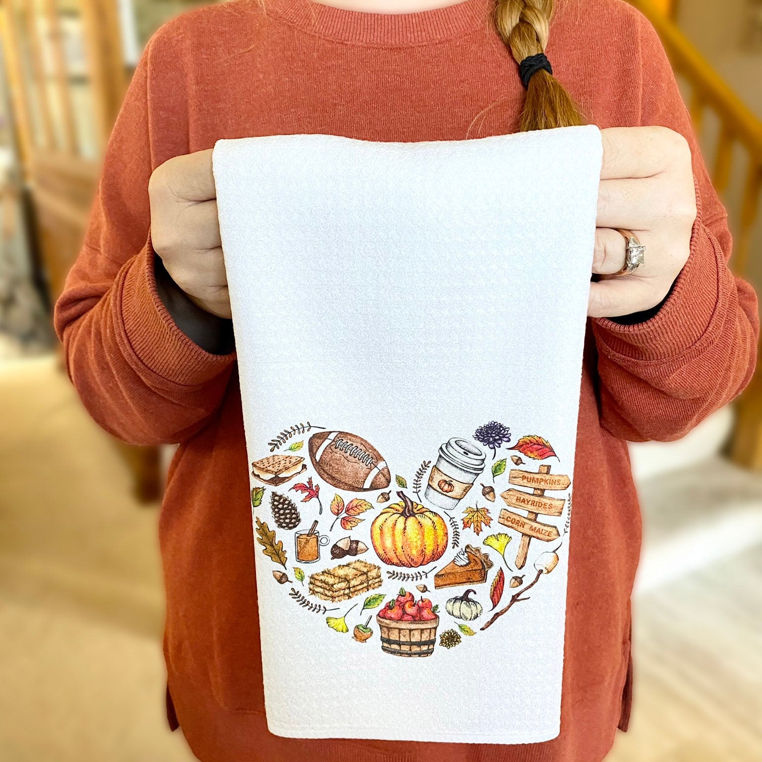 Super cute white Dishtowel with a watercolor collage of fall favorites including pine cone, leaves, pumpkins, smores, haybale, cider, caramel apple, pumpkin pie, pumpkin spice latte, a marshmallow on a stick, acorns and more!
