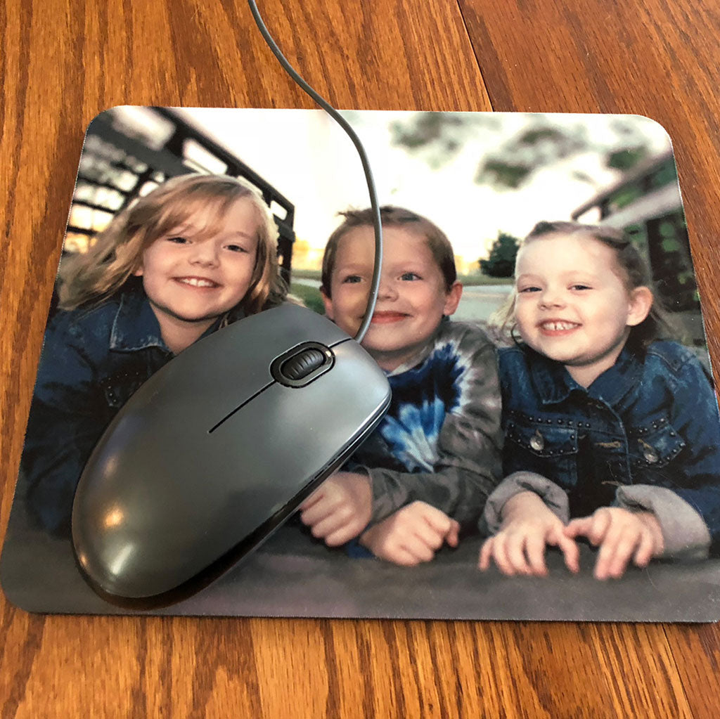 a personalized mouse pad with a photo of three children printed on it